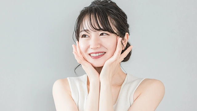 韓国コスメを賢く取り入れて自分磨きに成功し、潤いのある肌に満足している女性の笑顔